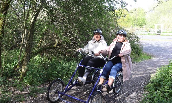 Two women riding a side by side bike